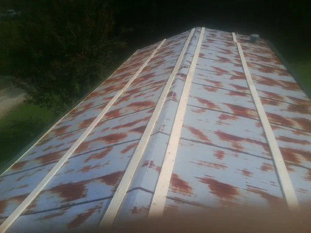 Rusted metal roof panels with new wood purlins before replacement — Storm Damage Roof Repair in North Royalton by Roofing Brothers