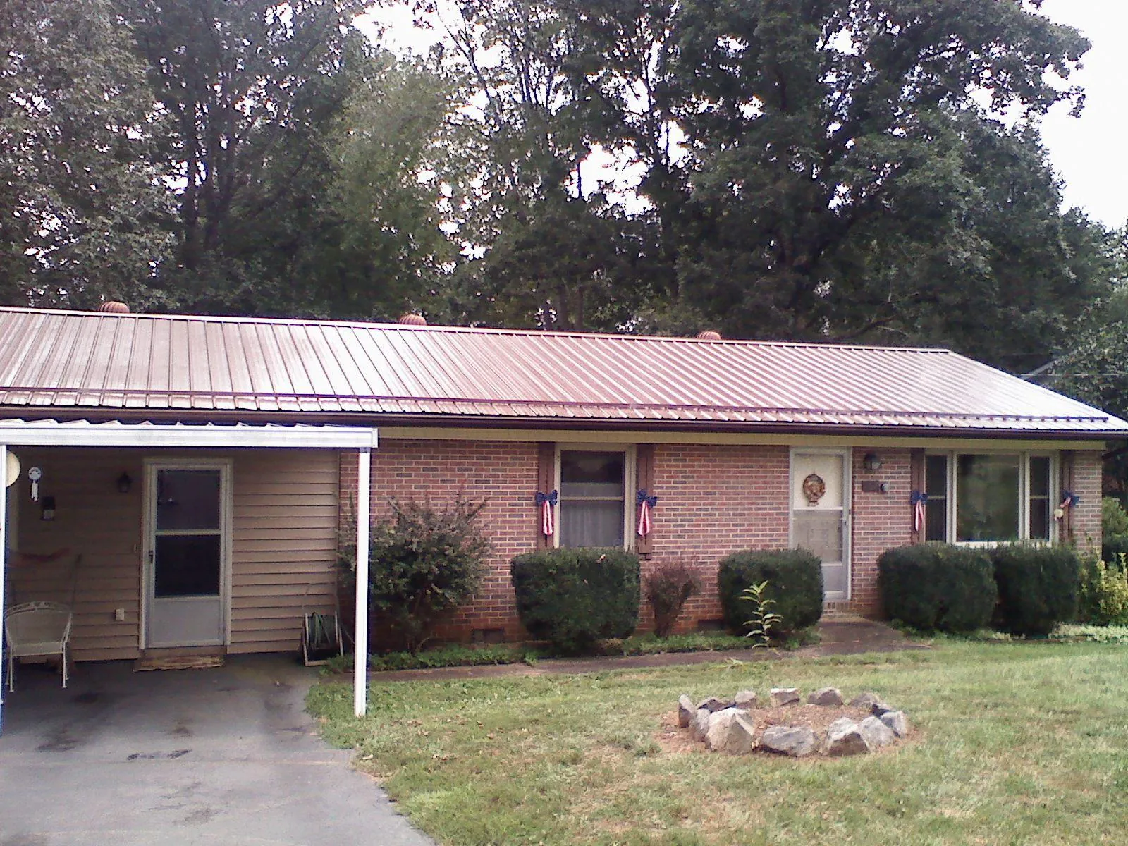 Bronze metal roof and carport on a brick ranch home — Roof Repair work by our crew in North Royalton